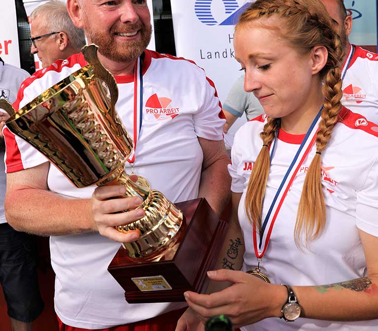 Die Sieger halten den Pokal in der Hand